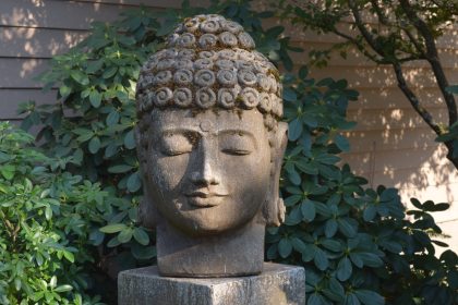A Buddha statue decorates the back patio of the UUCS building. 2016-08